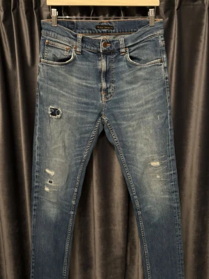 Nudie jeans - SLITNINGAR - Nudie jeans - skick 8/10, ser risigare ut än vad dom är, funkar fortfarande helt perfekt, men har sina lagningar, men som enligt mig gör jeansen snyggare! - modell: Lean Dean - storlek 30/32 - INGA HÅL IGENOM, endast fabricerade slitningar och lagningar - extremt feta jeans, med schyssta slitningar och även lite lagningar som styrker jeansens look - hör av er vid frågor🤝
