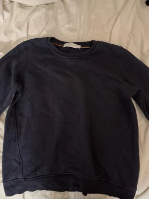 Mörkblå sweatshirt från Sail Racing - En stilren mörkblå sweatshirt från Sail Racing i storlek M. Tröjan har rund halsringning, långa ärmar och ribbade muddar vid ärmslut och nederkant. Perfekt för en avslappnad look och enkel att matcha med jeans eller joggers.