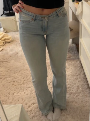 Ljusblå bootcut jeans - Säljer ett par ljusblå jeans med bootcut-modell och klassisk femficksdesign. Jeansen har hög midja och är tillverkade i ett mjukt denimtyg med lite stretch för skön passform. Perfekta för dig som gillar en avslappnad men ändå trendig look.