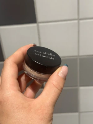 Annabelle Minerals ögonskugga Frappe - Mineralbaserad ögonskugga i nyansen Frappe från Annabelle Minerals. Kommer i en liten rund burk med svart lock. Färgen är en ljus beige/nude ton som passar perfekt för en naturlig look. Produkten är i puderform och enkel att applicera.