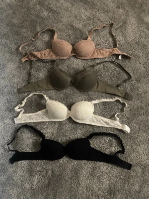 Fyra bhar i olika färger, spets och basic - Säljer fyra bhar i färgerna beige, olivgrön, vit och svart. Alla för 200kr eller 1 för 50kr. Alla är i storlek 70A men passar nog även 70B💕 Alla är från Ullared