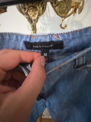 Ljusblå jeans från Paul & friends - Säljer ett par ljusblå jeans från Paul & friends i klassisk rak modell. Jeansen har fem fickor, bälteshällor och kontrastsömmar. Tillverkade i slitstark denim som ger en avslappnad vibe. Perfekta till sneakers eller boots.