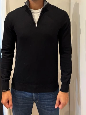 Svart stickad tröja merino  - Snygg svart stickad tröja från John Henric med halv dragkedja. Merinoulll 