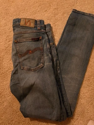 Blå jeans från Nudie Jeans - Säljer ett par jeans ifrån nudie i modellen tilted tor🧐. Storlek-w30 L30. 👕Nästan aldrig använt. Pris kan diskuteras vid snabb affär 🤩