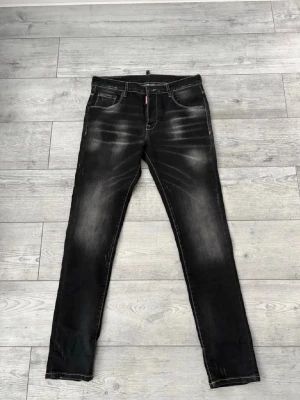 Svarta slim fit jeans med slitningar - Säljer ett par svarta slim fit jeans med snygga slitningar och tvättade detaljer. Jeansen har fem fickor, normal midja och dragkedja med knapp. Materialet är klassisk denim med stretch för extra komfort. Perfekta för en trendig och avslappnad look.      Storlek: 44  (((     W31/32 L31/32     )))