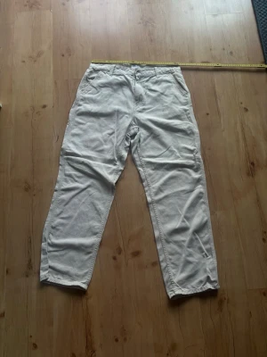 Beige cargo från Vailent - Snygga beige chinos från Vailent med klassisk rak passform och bälteshällor. Byxorna har två sidofickor och stängs med knapp och dragkedja. Tillverkade i ett mjukt bomullstyg som ger en avslappnad men stilren look.