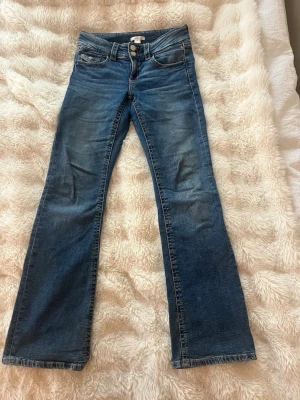 Blå bootcut jeans med slitningar