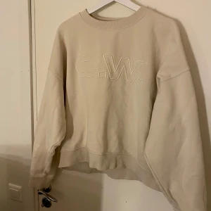 Beige sweatshirt från C.W. - Säljer en stilren beige sweatshirt från C.W. med broderad logga på framsidan. Tröjan har långa ärmar och en rund halsringning med ribbade muddar.