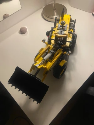 Lego Technic hjullastare gul - Säljer en detaljerad Lego Technic hjullastare i gult och svart med stora hjul och rörlig skopa framtill. Byggsatsen har många tekniska delar och realistiska funktioner som gör den extra rolig att bygga och leka med. Perfekt för dig som gillar maskiner och konstruktion.