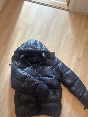 Svart pufferjacka Polo Ralph Lauren - Säljer en svart glansig Ralph lauren jacka, grym nu inför vintern St:XL sitter som L