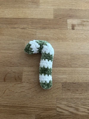 Virkad polkagris - Handgjord virkad polkagris i grönt och vitt, tillverkad av mjukt garn. Perfekt som dekoration till jul eller som en söt detalj i hemmet. Formen är klassisk böjd polkagris och materialet är fluffigt garn.
