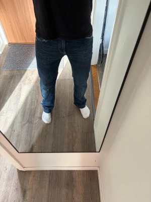 Mörkblå raka jeans herr dondup  - Säljer ett par mörkblå jeans med rak passform och klassisk femficksdesign. Jeansen har normal midja och är tillverkade i ett slitstarkt denimtyg. Perfekta för en avslappnad och stilren look.