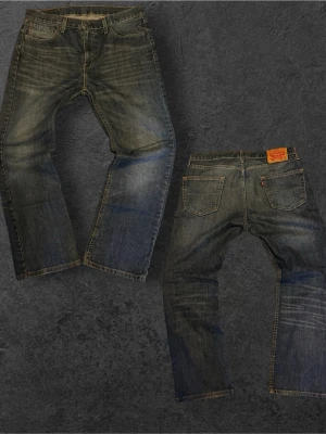 Sjukt feta vintage Levi's 527 blå jeans bootcut - Säljer ett par klassiska Levi's 527 jeans i blå denim med bootcut passform. Jeansen har slitningar och tvättade detaljer för en cool vintage-look, fem fickor och gylf med dragkedja. Perfekta för dig som gillar avslappnad stil.