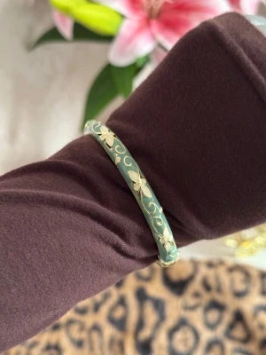Cloisonne bangle - Snyggt armband i grön emalj med guldfärgade detaljer och blommönster runt hela. Armbandet har en rund form.