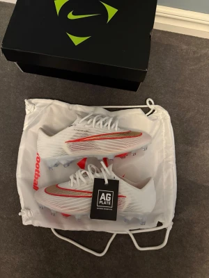 Nike mercurial superfly 11 elite  - Säljer mina helt oanvända Nike superfly 11 elite Ag från Nikes nya break em pack. Sjukt snygga men passade tyvärr inte mig. Allt på bilderna tillkommer. 