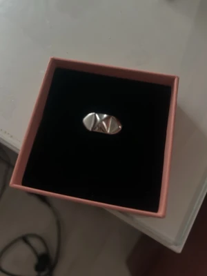 Edblad nit ring - STORLEK 17,50 mm. Säljer en chunky ring i silverfärg med ett coolt geometriskt mönster på ovansidan. Ringen har en bred design och en blank finish som ger ett modernt och edgy intryck. Perfekt för dig som gillar statement-smycken och vill sticka ut lite extra.  