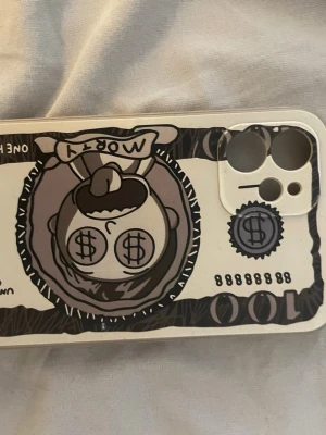 Mobilskal med Rick & Morty sedelmotiv - Unikt mobilskal i beige och svart med Rick & Morty-tema, där Morty syns på en tecknad sedel med dollartecken i ögonen. Skalet är gjort i tålig plast och har utskärningar för kamera och knappar. Perfekt för dig som gillar coola och roliga designer.