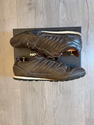 Bruna Adidas sneakers i läder - Snygga bruna sneakers från Adidas i läder. Vet inte vad middagen heter. Skorna är i storlek 43!📐 Skorna är i riktigt bra skick!✅👟 skriv vid funderingar! Postar inom 24h!🚚📦
