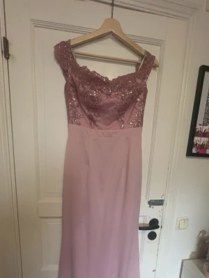 Lång rosa klänning  - Säljer en elegant lång klänning i rosa. Överdelen har vackra spets- och paljettbroderier. Kjolen är slät och faller snyggt. Perfekt för bal eller festkväll! Har en liten vit färgfläck på sig men är inget som man märker av. Kanske går bort i tvätten. Priset kan diskuteras 💕