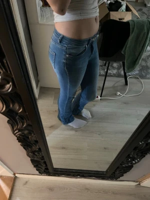 Blå bootcut jeans med stretch - Säljer ett par ljusblå bootcut jeans med stretchig passform och klassiska fem fickor. Jeansen har låg midja och är i ett mjukt denimtyg som sitter snyggt på benen. Perfekta för dig som gillar en avslappnad men ändå trendig look. Pris kan diskuteras❣️(jag är 172)