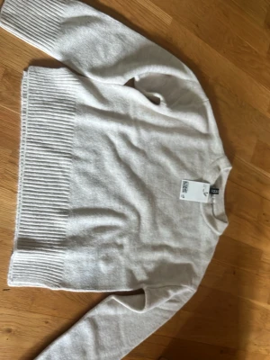 Beige stickad tröja från H&M - Säljer en ljusbeige stickad tröja från H&M i storlek XXS. Tröjan har rund halsringning, långa ärmar och bred ribbstickad kant nedtill samt vid ärmsluten. Perfekt för en enkel och clean look.