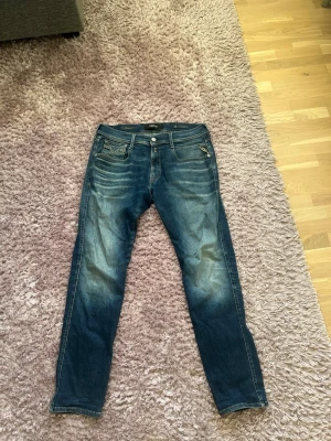 Replay Anbass Mörkblå slim fit jeans - Tjena! Säljer ett par mörkblå slim fit jeans från Replay med snygga tvättade detaljer framtill. Jeansen har en defekt som ni kan se på bild 3. Storleken är 32. Bara att höra av er om ni har några frågor!