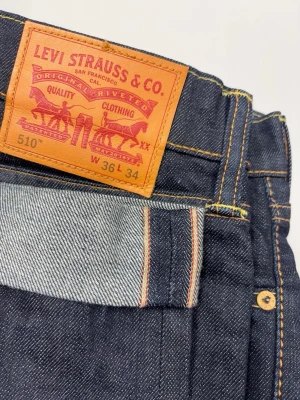 Selvedge Levis 510 Vintage Jeans - Väldigt snygga Selvedge Levis i mörk kvalitets denim. Jeansen är i mycket gott skick. Använda, men mycket kvar att ge! Regular fit.  Färg: Mörkare blå färg | Modell: 510 | Storlek: W36 L34 | Sitter mer som en W34 (kolla måtten nedan)  Mått: (Måttavvikelse +-1cm) A: 44 cm B: 112 cm C: 18 cm D: 30 cm  Tveka inte att höra av dig minsta fråga eller fundering!  Skickas snabbt!