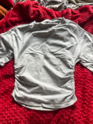 Vit kortärmad t-shirt - En basic vit t-shirt med korta ärmar och rund hals. Tillverkad i mjukt material som känns skönt mot huden. Perfekt att matcha med jeans eller kjol för en enkel och clean look.