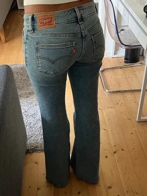 Levi's bootcut jeans i blå denim - Säljer ett par blå Levi's jeans i bootcut-modell. Jeansen har låg midja och ett stretchigt material. Storlek: W25 och L34. Använda ett fåtal gånger. 
