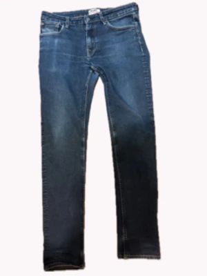 Blå raka jeans med slitningar - Snygga blå crocker jeans med raka ben och lätt slitna detaljer framtill. Storlek är 32/22. Priset ej hugget i sten bara att skriva vid frågor.