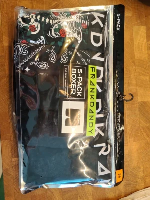 Frank Dandy 5-pack boxerkalsonger M - 5-pack boxerkalsonger från Frank Dandy i storlek M. Flera olika mönster och färger, bland annat svart med vita och röda detaljer samt bandanamönster. Snygg design och bekväm passform, perfekta för dig som vill ha variation i underklädeslådan. Oöppnad förpackning 