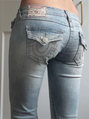 True religion low waist flare jeans  - Jätte snygga low waist jeans med ljus rosa stygn. Säljer enbart för att rensa ut, jeansen är uppklippa lite och har slitningar men absolut inget man tänker på! Skriv för mer bilder!!