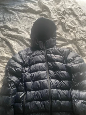 Svart peak peakproformace jacka - Säljer en svart peak preformance jacka i storlek 160, ett hål vid vänstra armbågen, utanför det är den i bra skick.