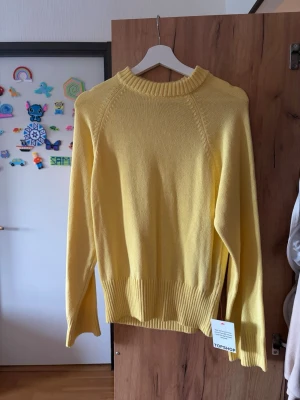Gul stickad tröja från Topshop - Snygg gul stickad tröja från Topshop med rund halsringning och breda ribbade muddar vid ärmslut och nederkant. Tröjan har en avslappnad passform och är perfekt för att liva upp garderoben med en färgklick.
