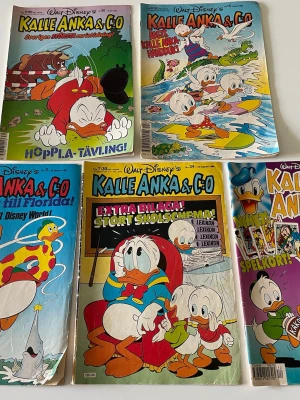 Kalle Anka & C:o serietidningar 90-tal - Samling med fem färgglada Kalle Anka & C:o serietidningar från 1990-talet. Omslagen pryds av Kalle Anka, Knattarna och andra Disneyfigurer i olika äventyr. Perfekt för dig som gillar klassiska Disney-serier och nostalgi.