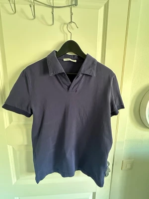 Blå kortärmad skjorta Tiger of Sweden - Snygg blå kortärmad skjorta från Tiger of Sweden. Skjortan har en klassisk krage och är tillverkad i mjuk bomull. Perfekt för en avslappnad men stilren look. Använd fåtal gånger och storlek S. Tveka inte att höra av dig för mer frågor!