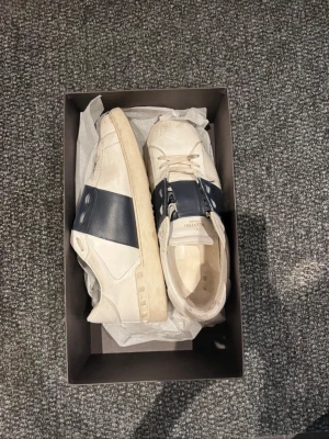 Valentino Open Garavani - Skor från Valentino | Storlek: 43 | Vit med marinblå detalj | sitter en laglapp vid hälarna annars fint skick (sista bild) | Box finns | FÖRST TILL KVARN |