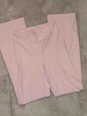 Ljusrosa yoga pants från Gina Tricot - Säljer ett par ljusrosa yoga pants från Gina Tricot  med V-formad linning. Mjukt och stretchigt material som sitter skönt..