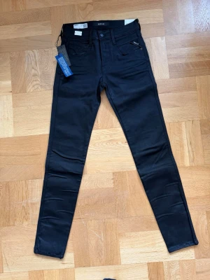 Svarta jeans från Replay - Svarta jeans från Replay, storlek W27 L32 och passformen Anbass. Hör av dig vid minsta fundering!