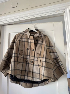 Rutig cape från Mango - Snygg beige och grå rutig capejacka från mango med dubbelknäppning