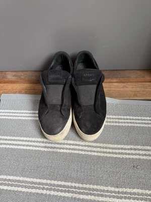 Svarta Axel Arigato - Stilrena Axel Arigato i mocka! Box och påse finns! Skorna är i gott skick kan synas lite slitage på mockan annars är det inga skador alls! 