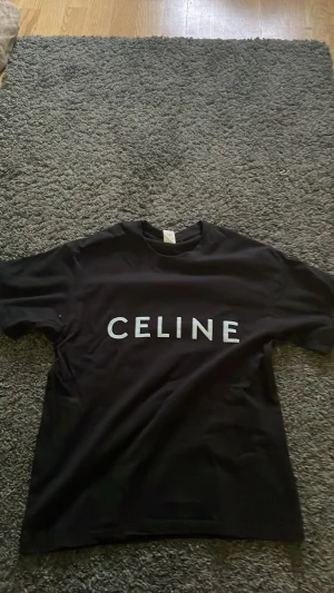 Svart  t-shirt med tryck - Snygg svart t-shirt från med stort vitt logotryck över bröstet. Klassisk passform och rund halsringning. Perfekt till jeans eller shorts för en clean och trendig look. Aldrig använda , väldigt billigt 🐼
