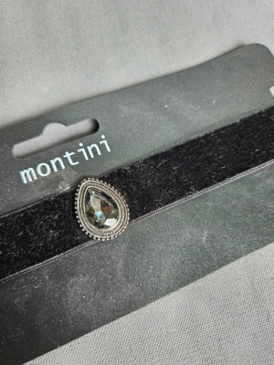 Halsband choker Montini - Säljer en svart sammetschoker från Montini med en droppformad dekoration i silverfärg och glittrig sten framtill. Halsbandet har kedjelås baktill. Perfekt accessoar för att lyfta din outfit.  Kan även hämtas I Partille