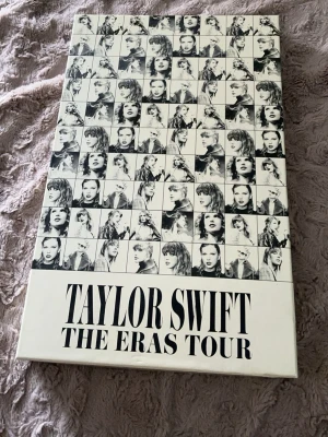 Taylor Swift The Eras Tour VIP box - Säljer en exklusiv Taylor Swift The Eras Tour VIP box med färgglada posters på Taylor Swift. Boxen innehåller vykort, samlarobjekt och en exklusiv brosch. Den kommer också med en super fin fake biljett och ett VIP pass. Jätte bra skick Perfekt för fans och samlare!