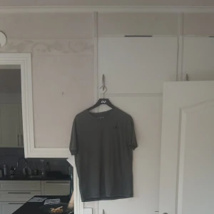 Mörkgrå basic t-shirt - En enkel mörkgrå t-shirt med rund hals och korta ärmar. Perfekt till jeans eller shorts för en avslappnad look. Tillverkad i mjukt bomullsmaterial för skön känsla hela dagen.