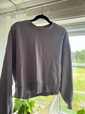 Ljuslila oversized hoodie - En stilren ljuslila hoodie med avslappnad passform och rund halsringning. Tillverkad i mjukt bomullsmaterial och har långa ärmar. Perfekt för en chill och enkel look.