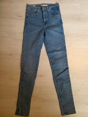 Blå skinny jeans med hög midja från Levi’s - Snygga blå skinny jeans med hög midja och klassisk femficksmodell. Jeansen har smal passform hela vägen ner och är gjorda i ett stretchigt denimtyg för extra komfort. Perfekta till en avslappnad stil och passar till det mesta.