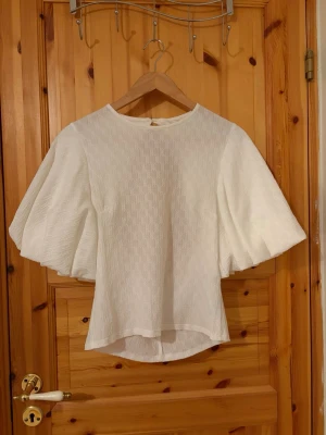 NAKD vit topp med ballongärmar och öppen rygg - Vit topp från NAKD. Mycket bra skick, använt fåtal gånger och har inga defekter.  