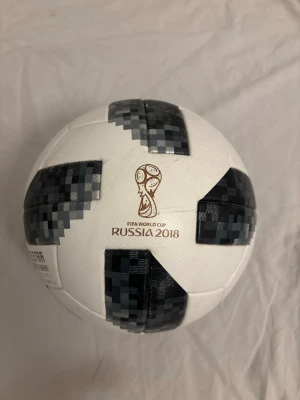 Adidas Telstar 18 fotboll VM 2018 - Kostar 5000 nypris. Säljer en Adidas Telstar 18 fotboll från FIFA World Cup Russia 2018. Bollen är vit med svart och grått pixelmönster och har officiell matchboll-design. Perfekt för dig som älskar fotboll och vill ha en ikonisk boll från VM. Samt perfekt för dig som tycker om fotboll och fotbollens nostalgi 2018 ett av de bästa vm:n någonsin! Aldrig använt bollen endast pumpat upp den. Tar ut luften om du vid skärmen just nu vill köpa! 