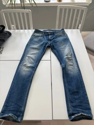 Replay jeans - Riktigt snygga replay jeans i blå färg med snygga slitningar. Jeansen har tyvärr spruckit i mellangärdet det är lagat men kanske inte de bästa arbetet som gjorts… Se sista bilden.   Hör av dig vid frågor eller funderingar, är villig att för handla om priset!😀